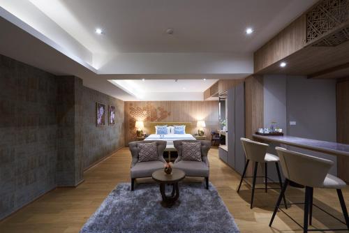 a hotel room with a bed and a table and chairs at Almas Hotel Bangkok in Bangkok