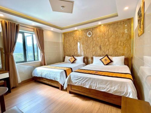 a hotel room with two beds and a window at Hotel Minh Thắng 2 in Con Dao