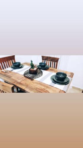 a wooden table with black plates and a plant on it at La Plaza in Formosa