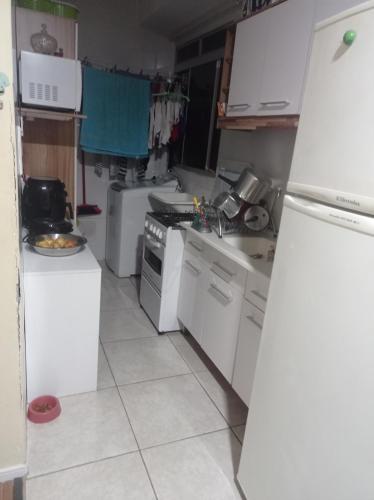a kitchen with white appliances and a white refrigerator at Condomínio ágata in São Paulo