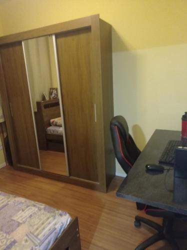 a room with a desk and a cabinet with a mirror at Condomínio ágata in São Paulo