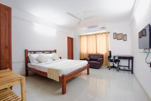1 dormitorio con 1 cama y 1 silla en Achates Corporate Services en Bangalore