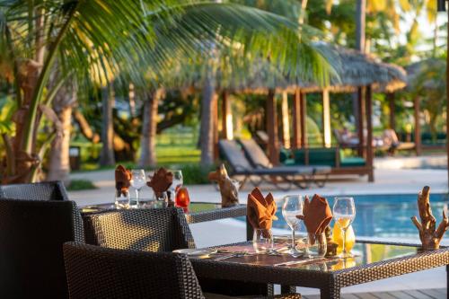 a table with wine glasses on it next to a pool at Lomani Island Resort & Spa in Malolo Lailai