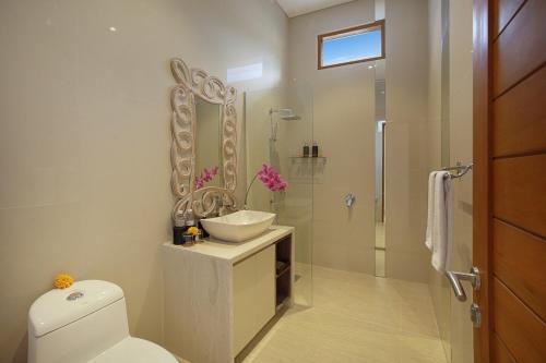 a bathroom with a toilet and a sink and a shower at Holl Villa by Wildflower Group in Legian