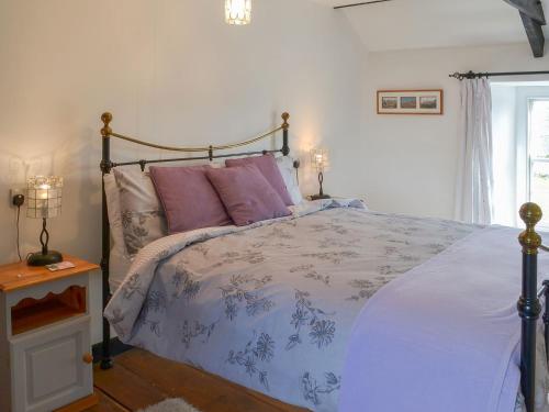 a bedroom with a bed with purple and pink pillows at Culvada in Treknow