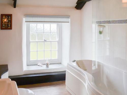 a bathroom with a window and a tub and a sink at Culvada in Treknow