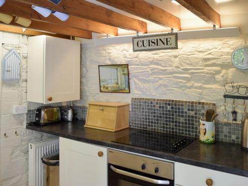 uma cozinha com um balcão e um cartaz que lê cozinha em Cranmere em Salcombe