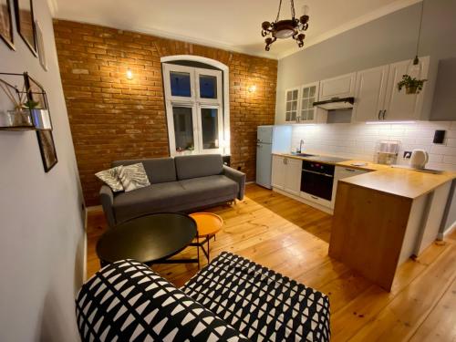 pequeña sala de estar con sofá y cocina en Apartament Odrzanka, en Gryfino