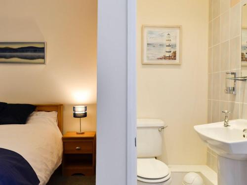 a bathroom with a bed and a sink and a toilet at Poets Retreat in Cockermouth