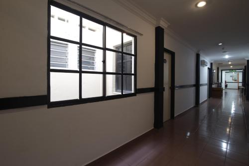 a hallway with large windows in a building at G CITY HOTEL in Teluk Intan