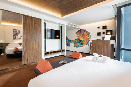 a hotel room with a large bed and a large window at Maitria Mode Sukhumvit 15 Bangkok - A Chatrium Collection in Bangkok