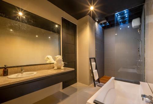 een badkamer met een wastafel en een grote spiegel bij Villa Bali Art - Canggu in Canggu