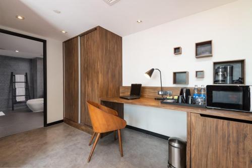 a room with a desk with a computer on it at Maitria Mode Sukhumvit 15 Bangkok - A Chatrium Collection in Bangkok