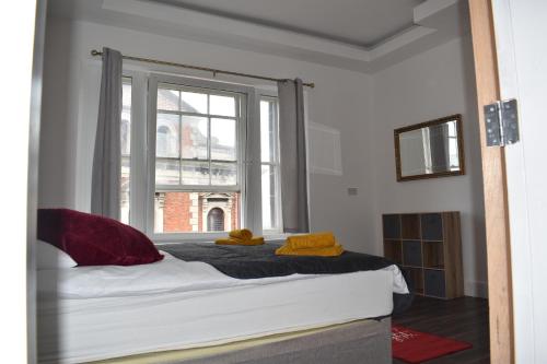 uma cama num quarto com uma grande janela em Celyn Room em Denbigh