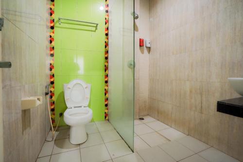 a bathroom with a toilet and a shower and a sink at RedDoorz near Pantai Pede in Labuan Bajo