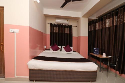 a bedroom with a bed with red and black stripes at Prabha Palace Lodge in Kamakhya