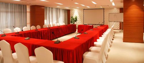 sala konferencyjna z czerwonymi stołami i białymi krzesłami w obiekcie Premium Hotel Ulaanbaatar w Ułan Bator