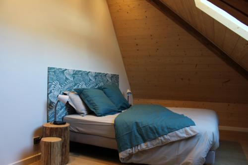 una camera da letto con letto e cuscini blu di grand appartement privé neuf avec loggia a Orchamps-Vennes