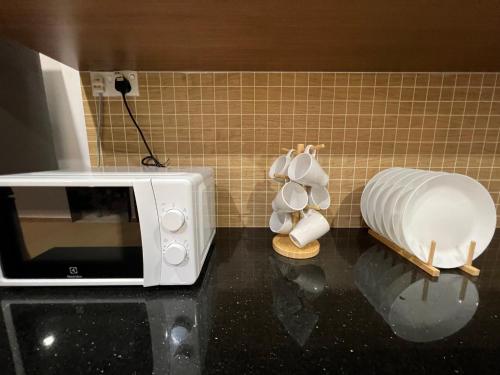 a microwave sitting on a counter next to a kitchen at Mujito 8PAX NearTC, DinosaurLand, PoolTable, PS4 in Kuantan