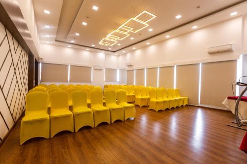 an empty room with yellow chairs in a room at Clubhouse Nami Residency - Sabarmati Riverfront Ahmedabad in Ahmedabad