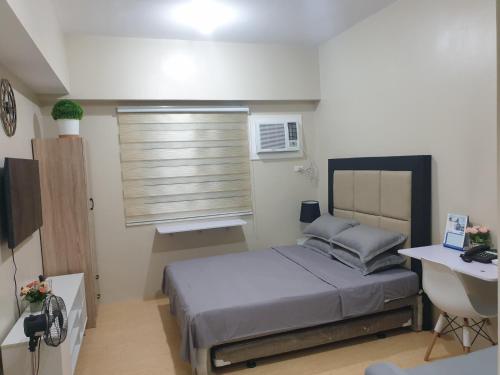 a small bedroom with a bed and a window at CunduNiAia Sunvida Tower Condominium Unit Across SM Cebu in Cebu City
