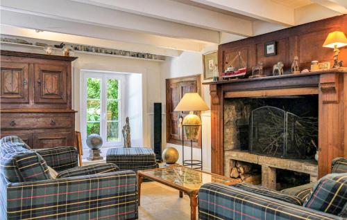 a living room with couches and a fireplace at Nice home in ST GERMAIN DES VAUX with 3 Bedrooms and WiFi in Auderville