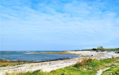 a rocky beach with the ocean in the background at Gorgeous Home In St Germain Des Vaux in Auderville