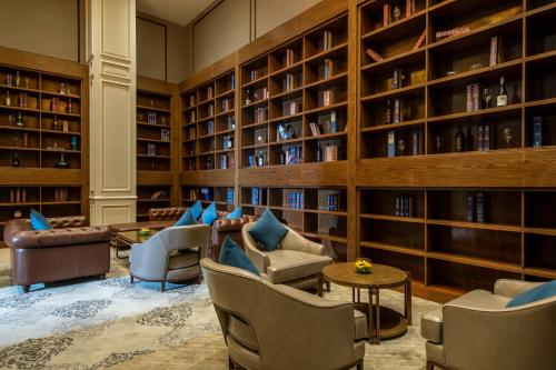a library with couches and chairs and bookshelves at FLC Grand Hotel Samson in Sầm Sơn