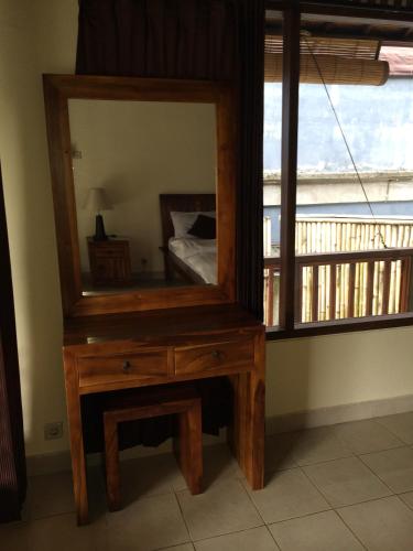 a wooden dressing table with a mirror on top of it at Raka Rai Bungalows in Ubud