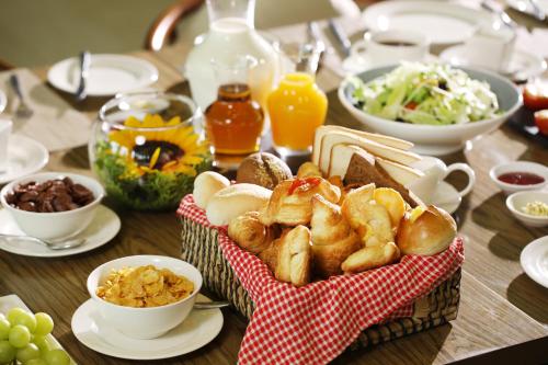 a table topped with a basket of bread and other foods at FLC Grand Hotel Samson in Sầm Sơn