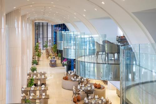 a lobby with tables and chairs and a glass ceiling at FLC Grand Hotel Samson in Sầm Sơn