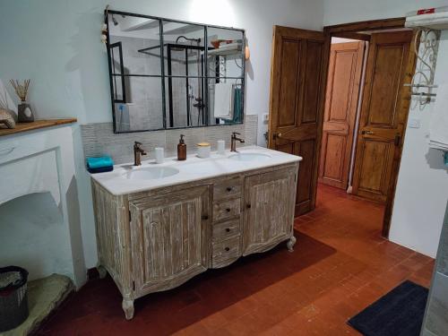 une salle de bain avec un lavabo et un miroir dans l'établissement Le Ptit Cottage, à Nyons