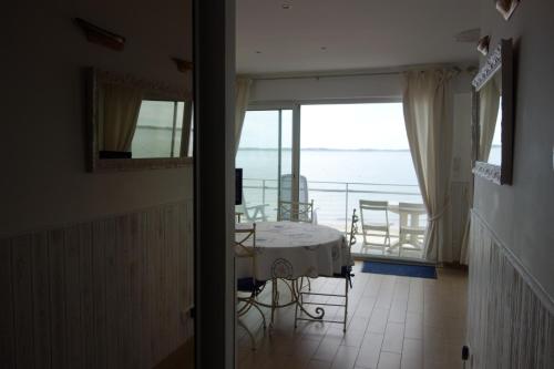 une pièce avec une table et une vue sur l'océan dans l'établissement Appartement ARCACHON Perreire Premiere ligne les pieds dans l eau vue magnifique sur le bassin, à Arcachon