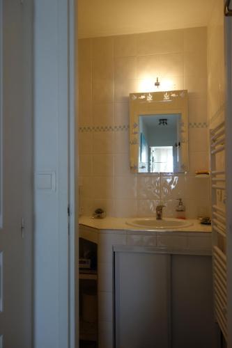 une salle de bain avec un lavabo et un miroir dans l'établissement Appartement ARCACHON Perreire Premiere ligne les pieds dans l eau vue magnifique sur le bassin, à Arcachon