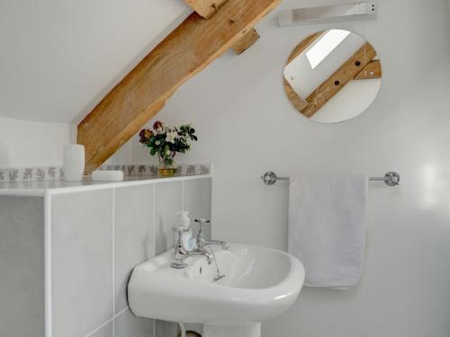 a white bathroom with a sink and a mirror at Stanley Barn in Stonehouse