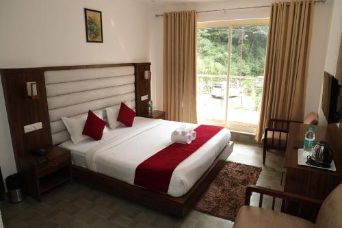 ein Schlafzimmer mit einem Bett mit einem Teddybär drauf in der Unterkunft Hotel Cordelia inn in Rishikesh