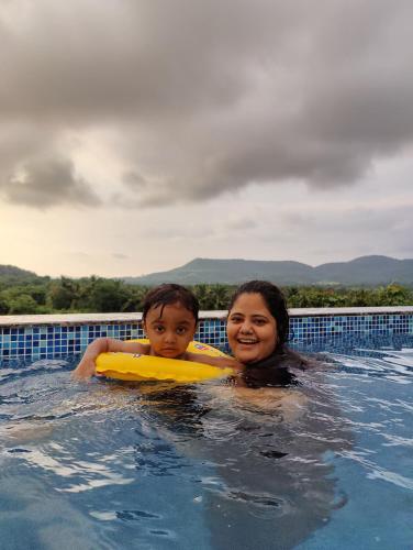 a woman and a child in a swimming pool at Rajput Farm in Alibaug