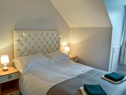 a bedroom with a large white bed with two lamps at Brick Cottage 1-uk13674 in Palnure