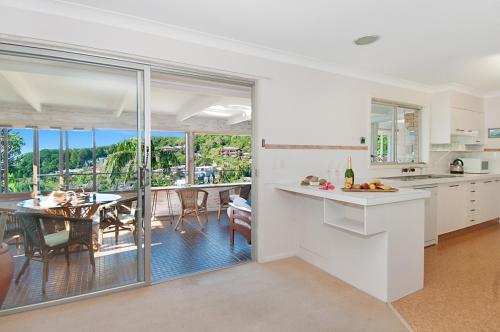 a kitchen and dining room with a view of a dining table at WategosRent in Byron Bay