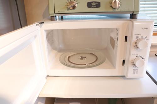 a microwave oven sitting on top of a shelf at HOCO Kawaguchiko in Azagawa