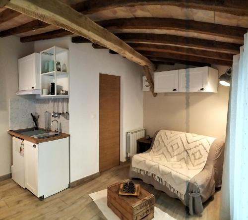 a bedroom with a bed and a kitchen in a room at Les castagnèdes in Céret