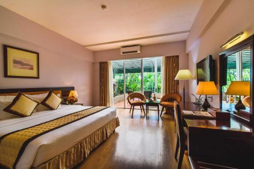 a hotel room with a large bed and a desk at Mondial Hotel Hue in Hue