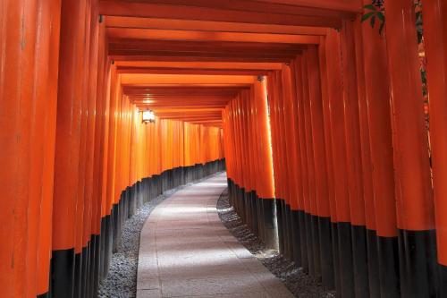 a corridor of orange torii gates at a shrine at ibis Styles Kyoto Shijo in Kyoto