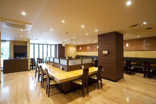 uma sala de jantar com uma mesa de madeira e cadeiras em Pearl Hotel Kayabacho em Tóquio