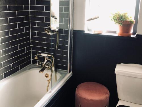 a bathroom with a shower and a tub with a toilet at Woodend in Maxwelltown