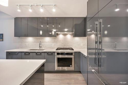 a kitchen with gray cabinets and a stove top oven at ARIES PALACE, LUXURY RESIDENTIAL CONDO in CITY of RICHMOND in Richmond