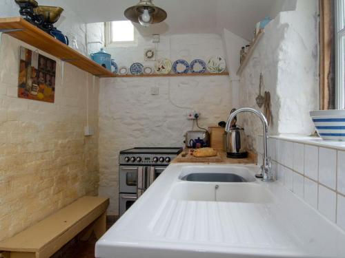 uma cozinha com um lavatório e um fogão em Avebury Cottage em Avebury