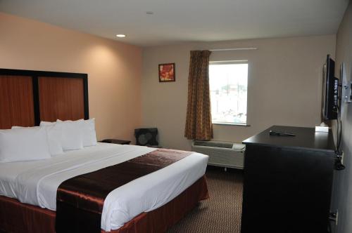 a hotel room with a bed and a window at Paradise Inn & Suites in Baton Rouge