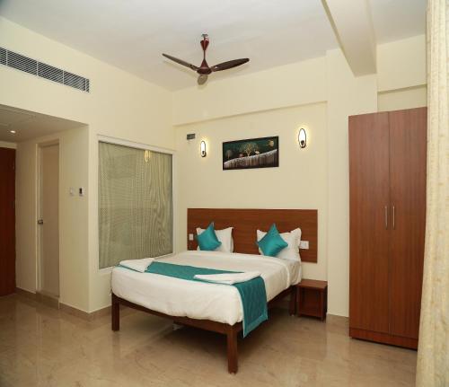 a bedroom with a large bed with blue pillows at Hotel Royal Chola in Kanchipuram