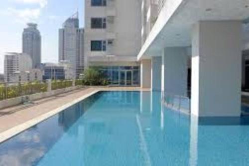 a large blue swimming pool in a building at Staycation in Manila (2 min. walk to Robinson's) in Manila